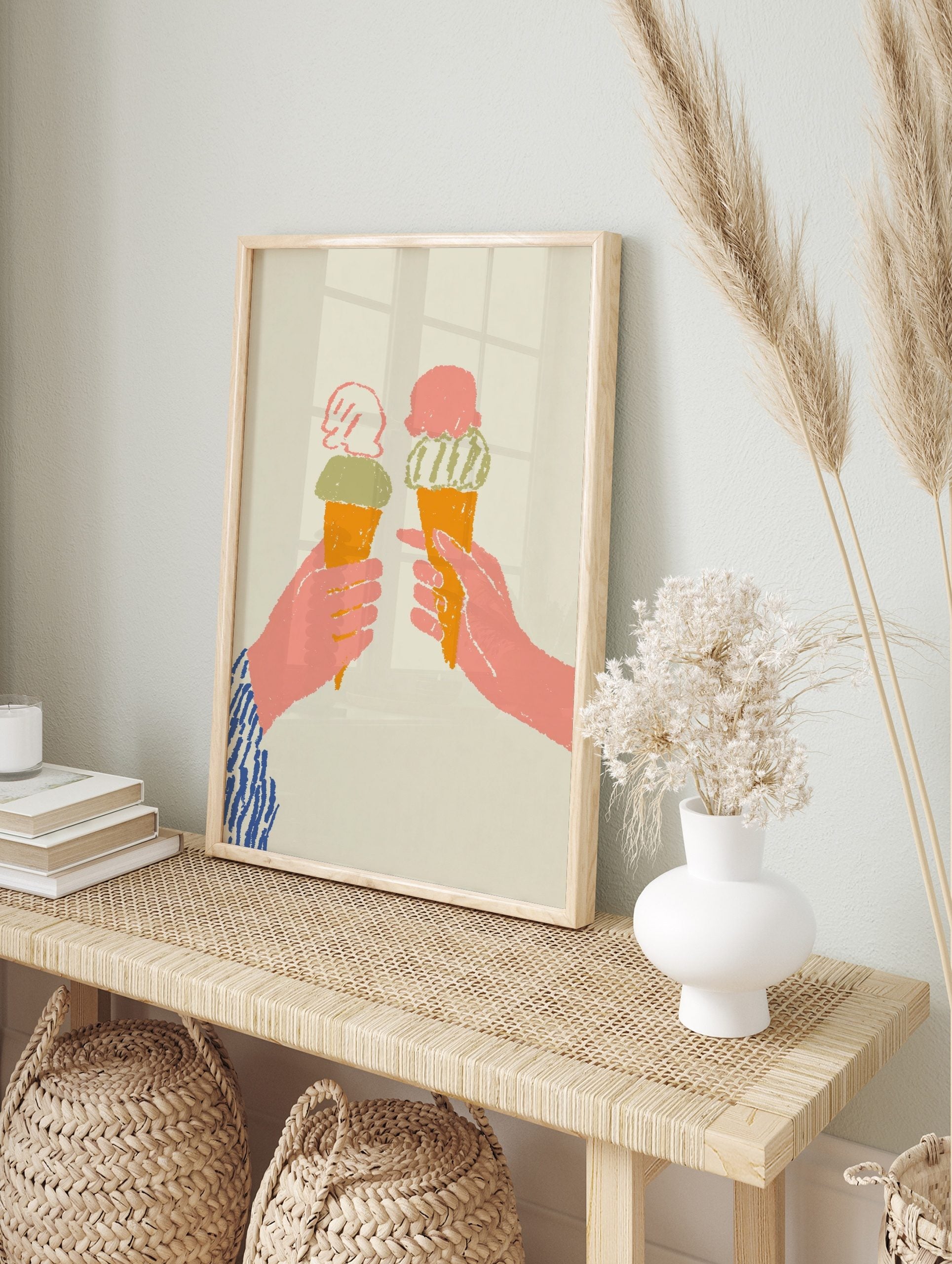 Two hands holding orange ice cream cones with pink and green scoops, on a light beige, in an alternate framed mockup