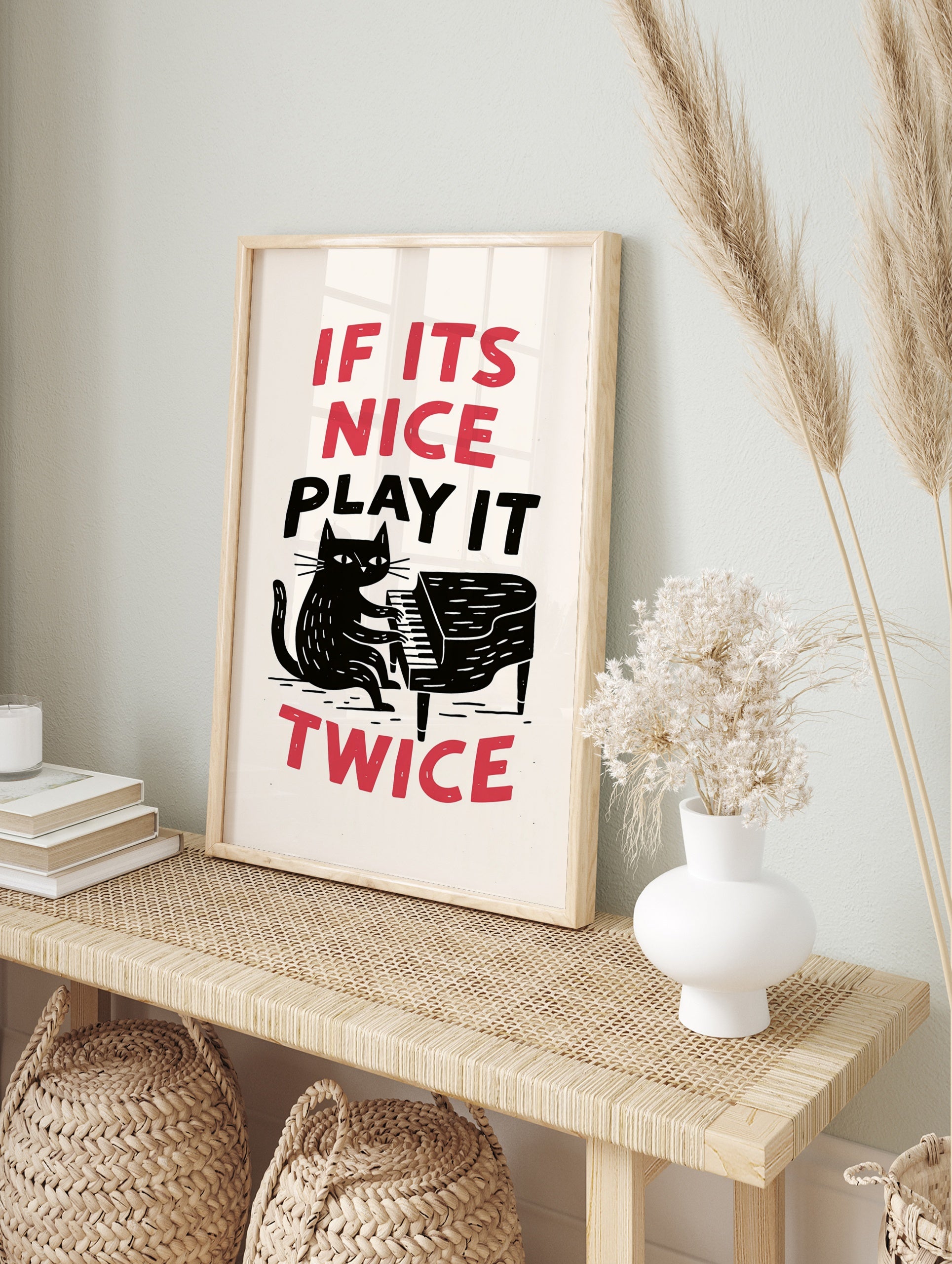 Illustration of a black cat playing a grand piano with the text If Its Nice Play It Twice in, in an alternate framed mockup