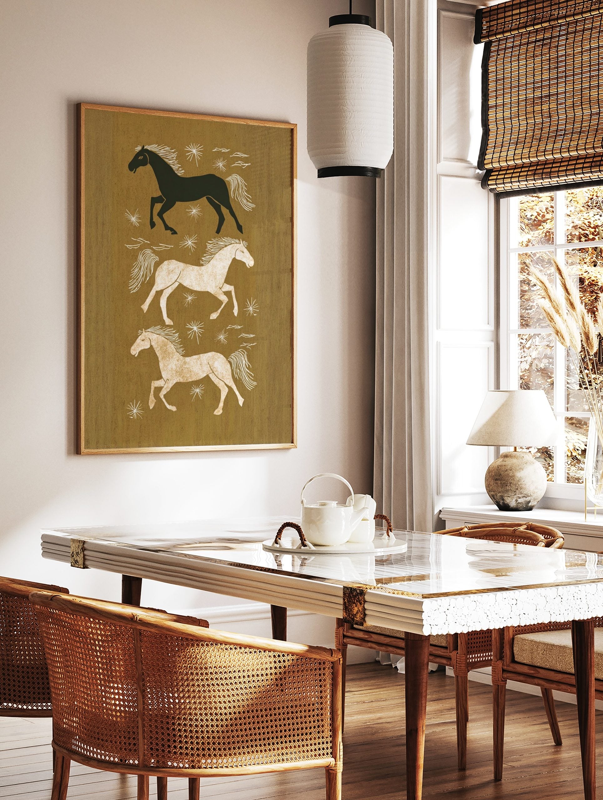 Three illustrative running horses in black, white, and tan on an earthy brown background with white, in a styled room mockup