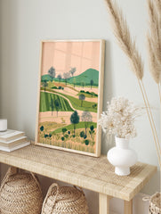 Illustrative landscape art print with rolling green hills, cultivated fields, and dotted, in an alternate framed mockup
