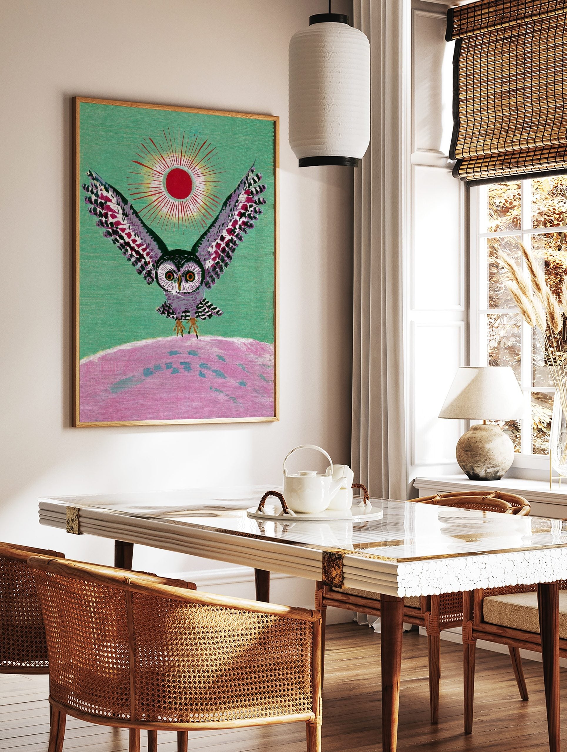 Illustrative owl with spread wings, red sun, and pink landscape on green background wall art, in a styled room mockup