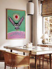 Illustrative owl with spread wings, red sun, and pink landscape on green background wall art, in a styled room mockup