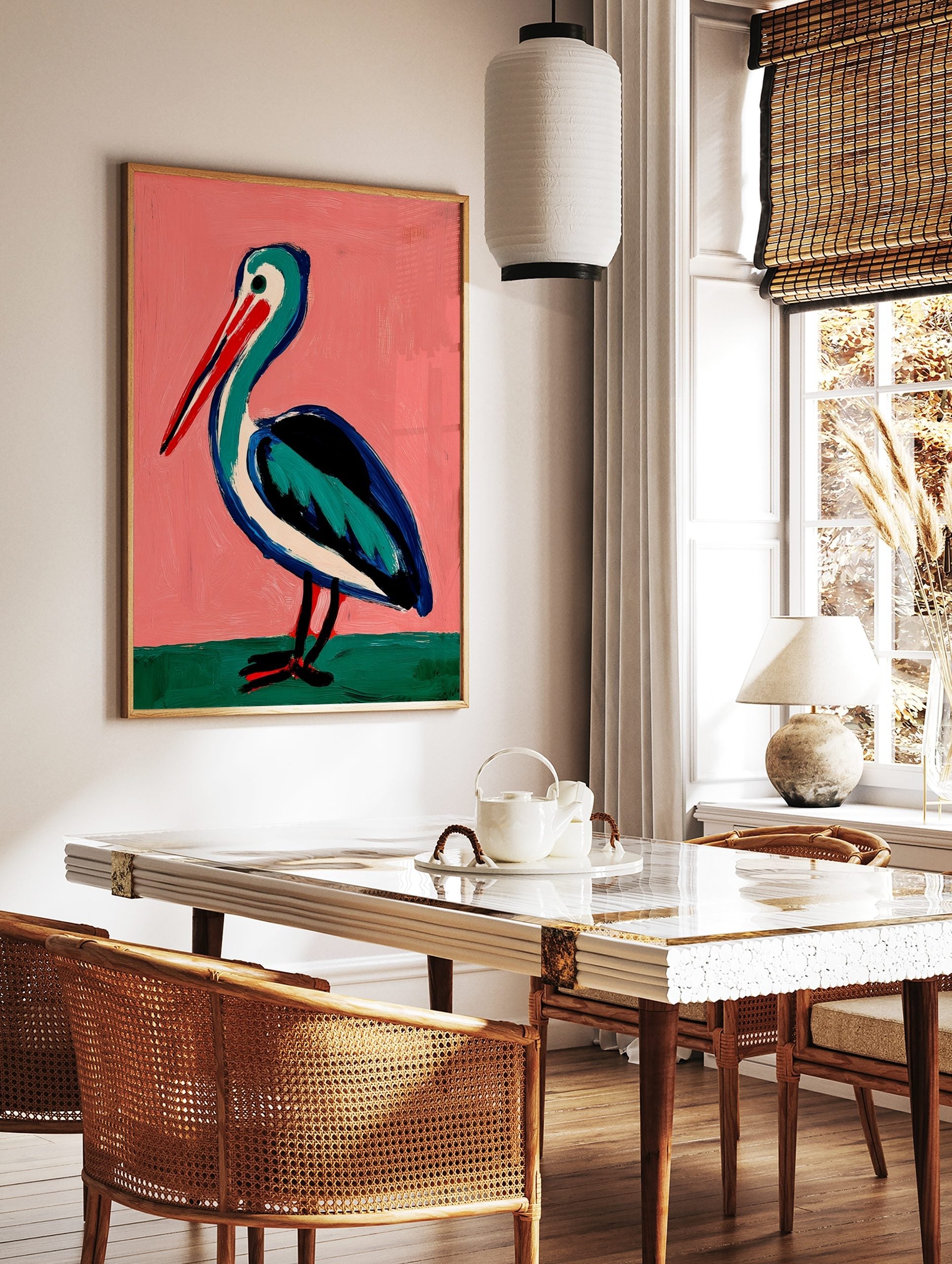 Illustrative painting of a pelican with a red beak, teal and blue body on a pink background, in a styled room mockup