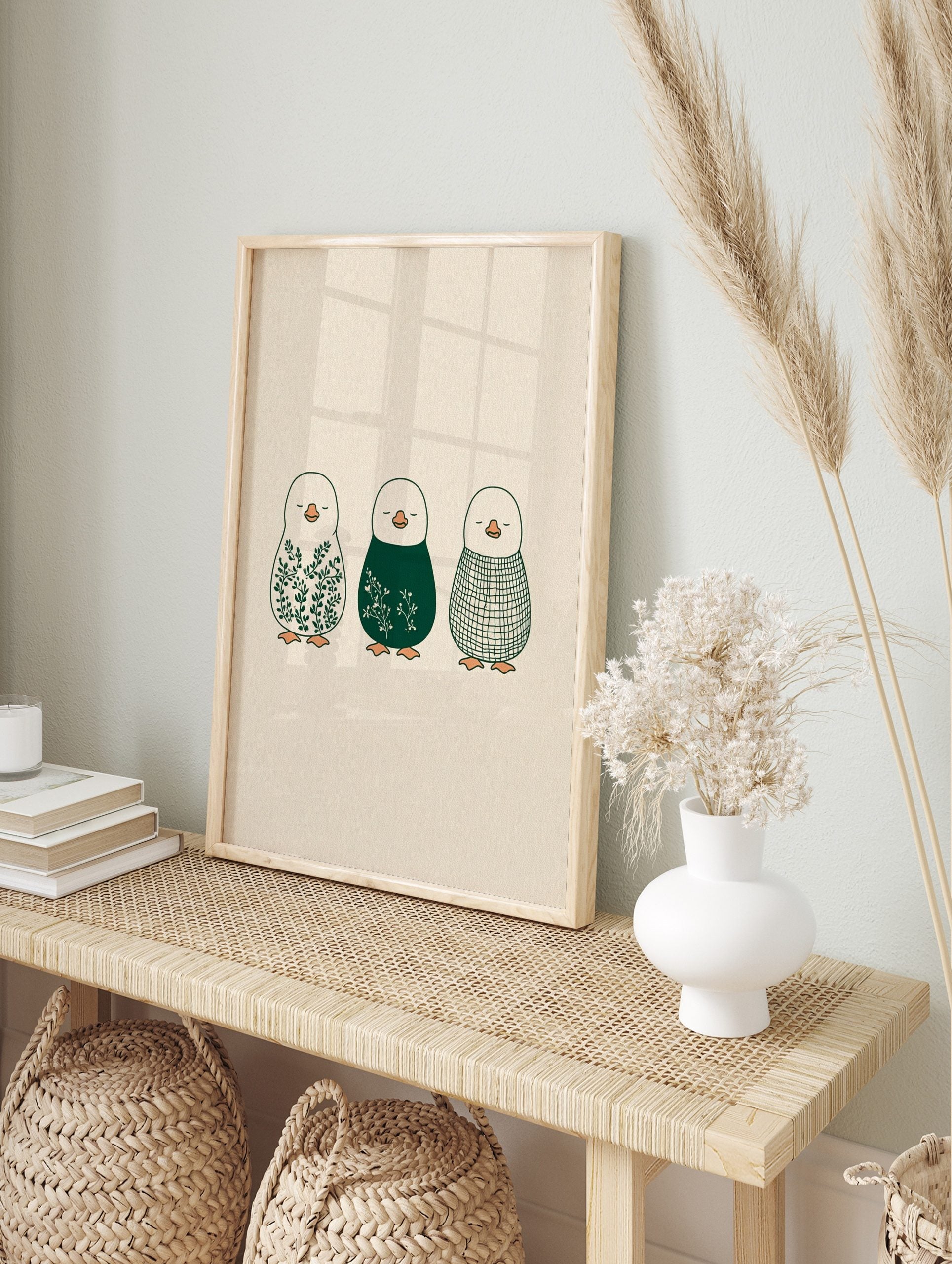 Illustrative penguin wall art featuring botanical leaves, white florals, and a plaid pattern, in an alternate framed mockup