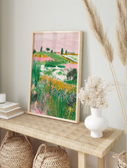 Illustrative landscape art print with green hills, pink sky, a red-roof house, and foreground, in an alternate framed mockup