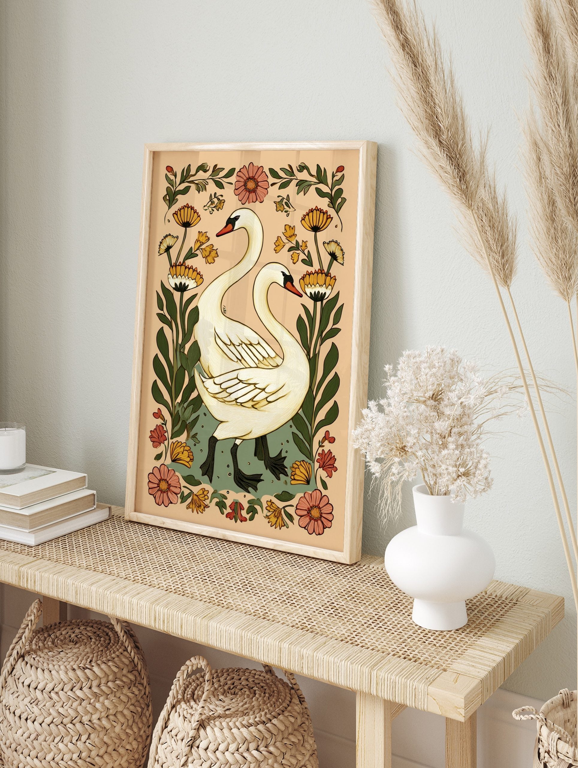Illustrative white swans with long necks and black webbed feet, surrounded by orange and pink, in an alternate framed mockup