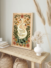 Illustrative white swans with long necks and black webbed feet, surrounded by orange and pink, in an alternate framed mockup