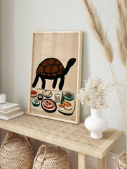 Illustrative brown and black turtle above a table with various food dishes and a glass on a, in an alternate framed mockup