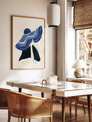 Illustrative wall art of a figure in a large, textured blue hat, with one hand holding the brim against a cream background. - Image 2