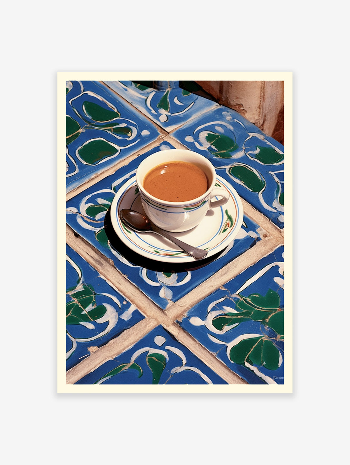 A cup of coffee with a spoon on a saucer, placed on a blue and green patterned tile surface.