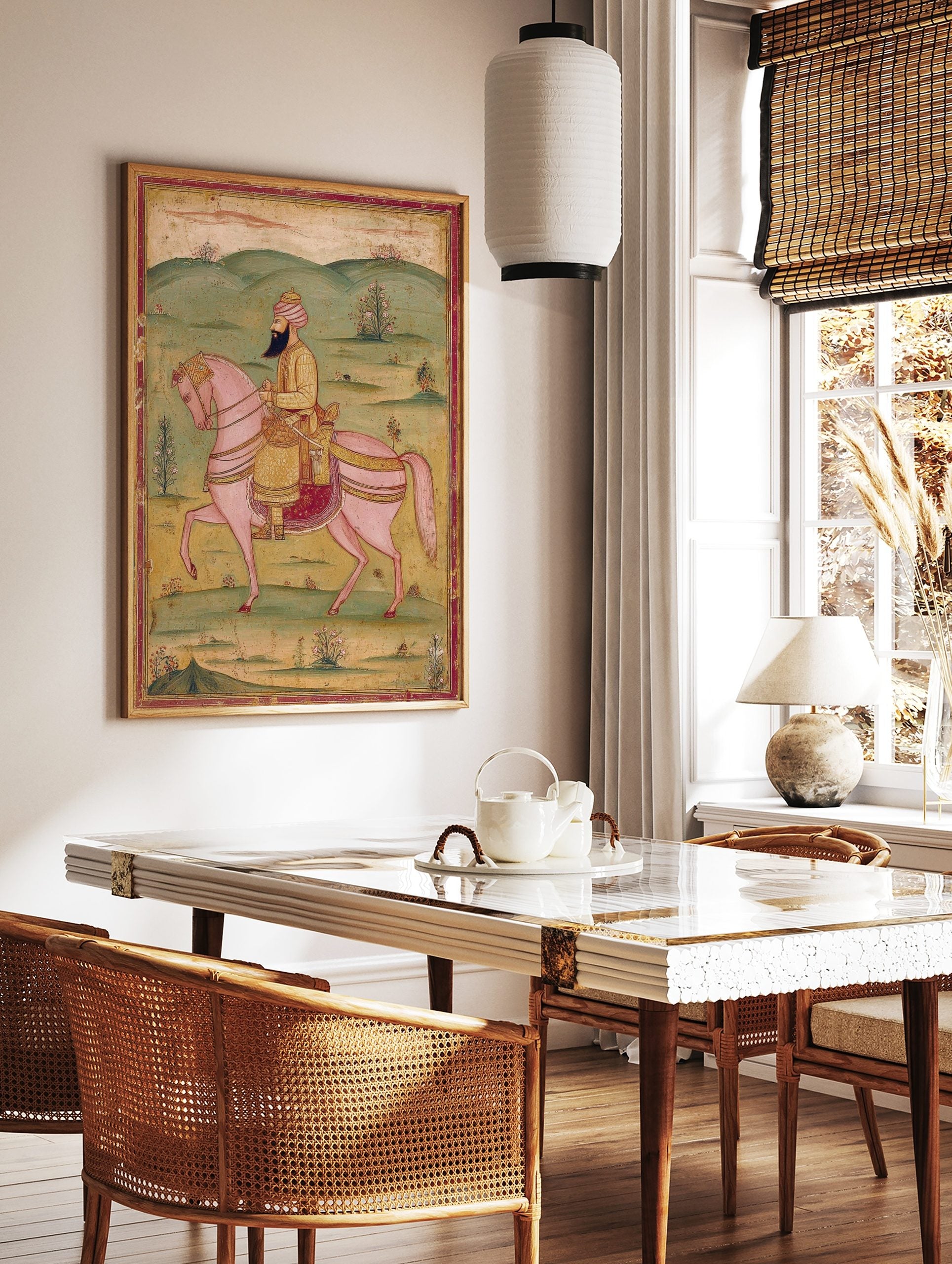 Indian miniature painting of a bearded man in gold tunic and turban riding a pink horse in a green, in a styled room mockup