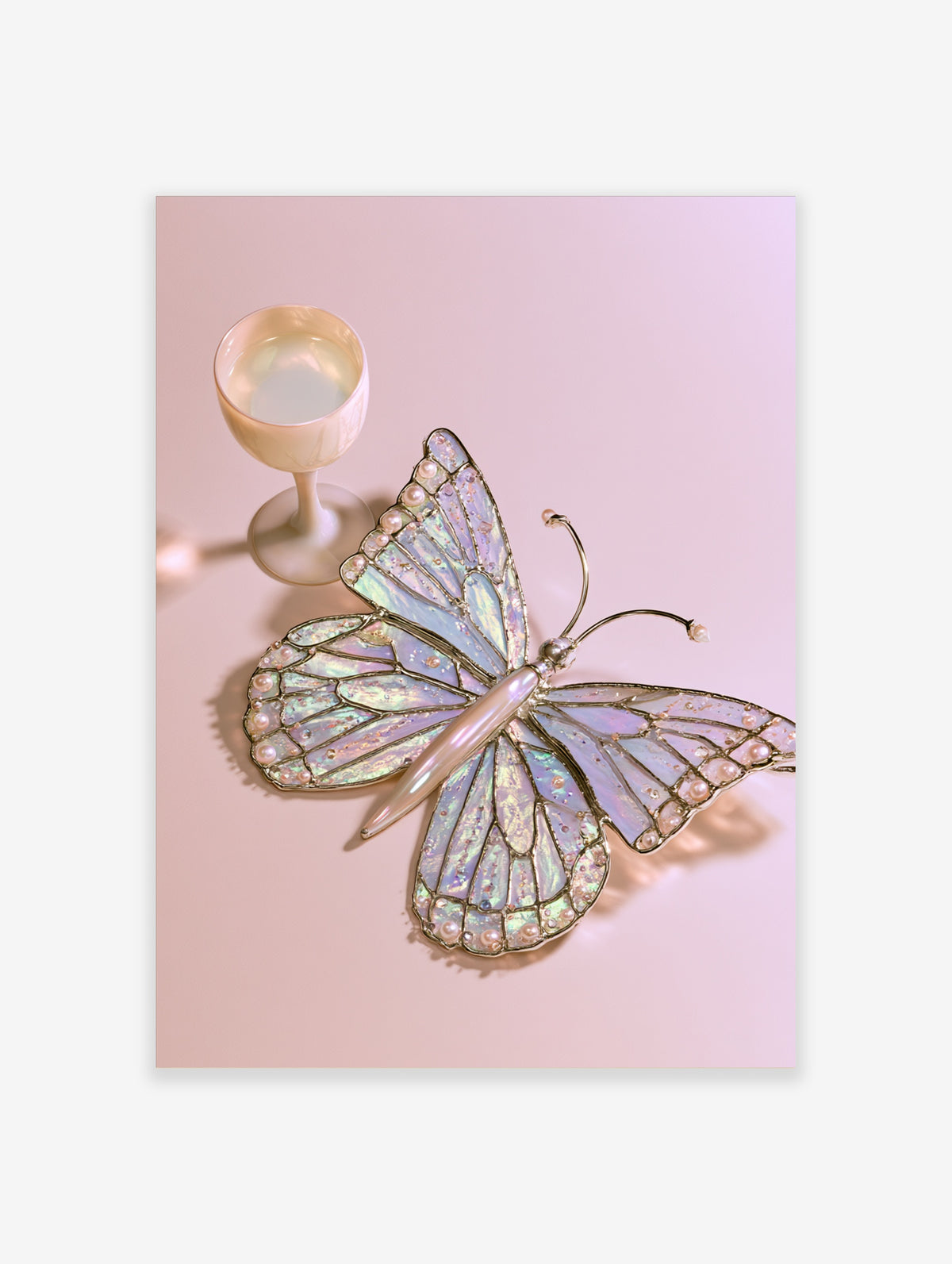 Iridescent butterfly wall art with pearl accents and a cream goblet on a pale pink background