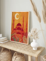 Stylised Islamic mosque with red domes, minarets, and crescent moon against an orange sky, in an alternate framed mockup