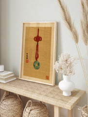 Jade bi pendant with red knot and calligraphy on tan textured background, in an alternate framed mockup