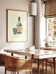 Japanese Awamori liquor bottle and cup woodcut print with orange kanji typography on an off-white, in a styled room mockup