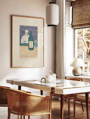 Japanese woodblock print of a chef with sake bottle and glass at a counter, in blue, cream, and, in a styled room mockup