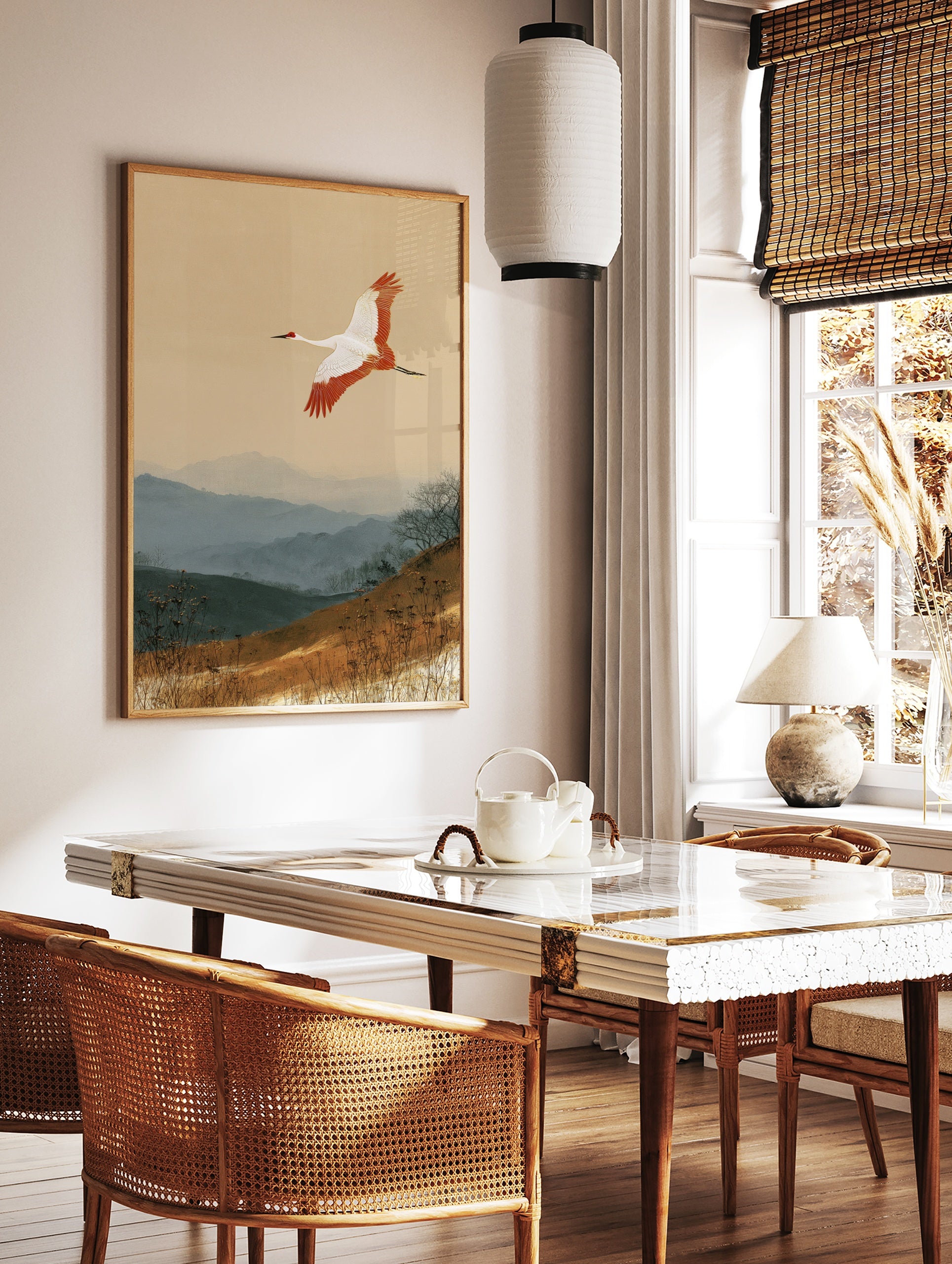 Japanese red-crowned crane flying over misty blue mountains and earthy grass landscape art print, in a styled room mockup