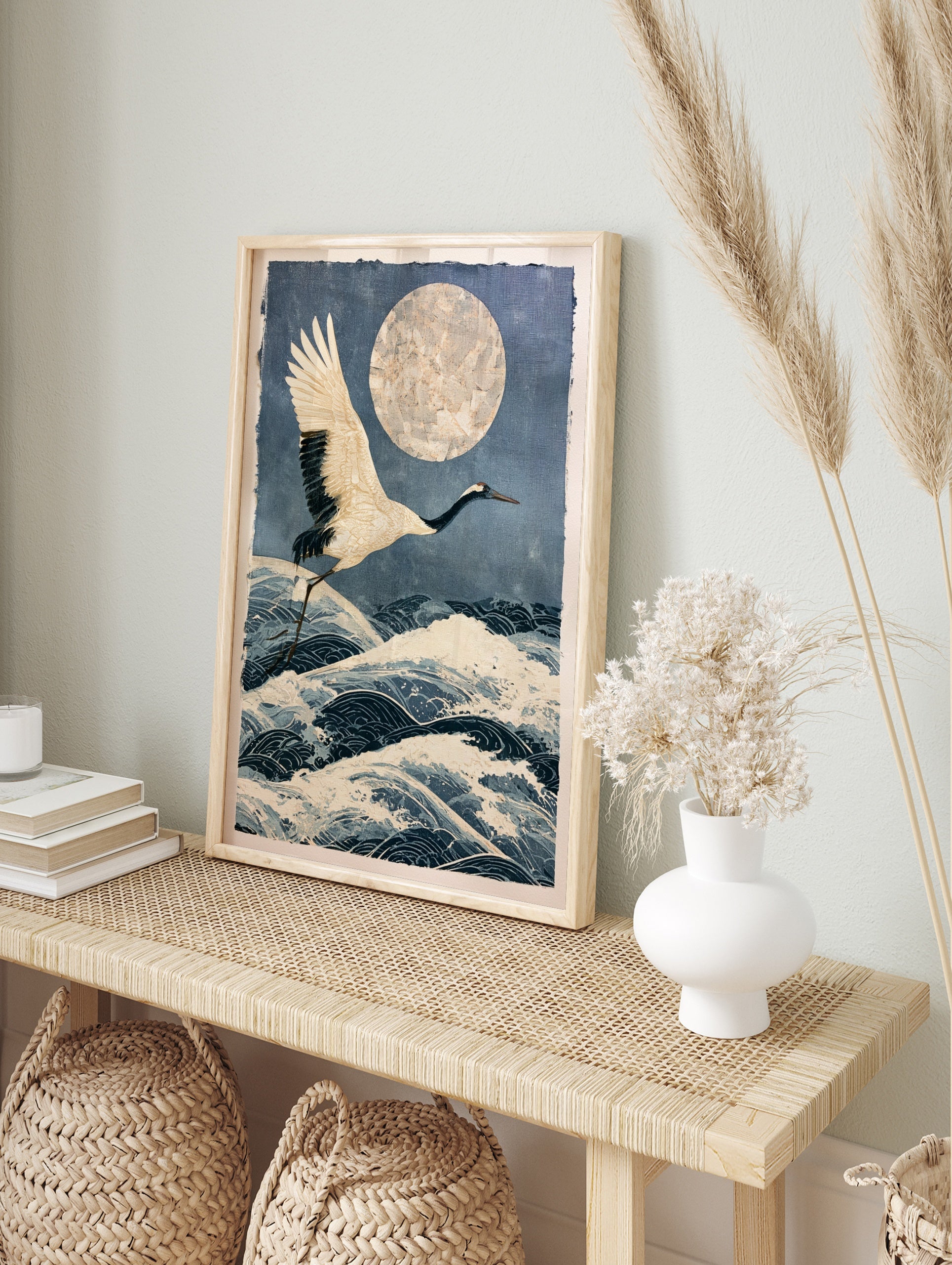 Japanese crane in flight over stylized ocean waves and a large textured moon in an, in an alternate framed mockup