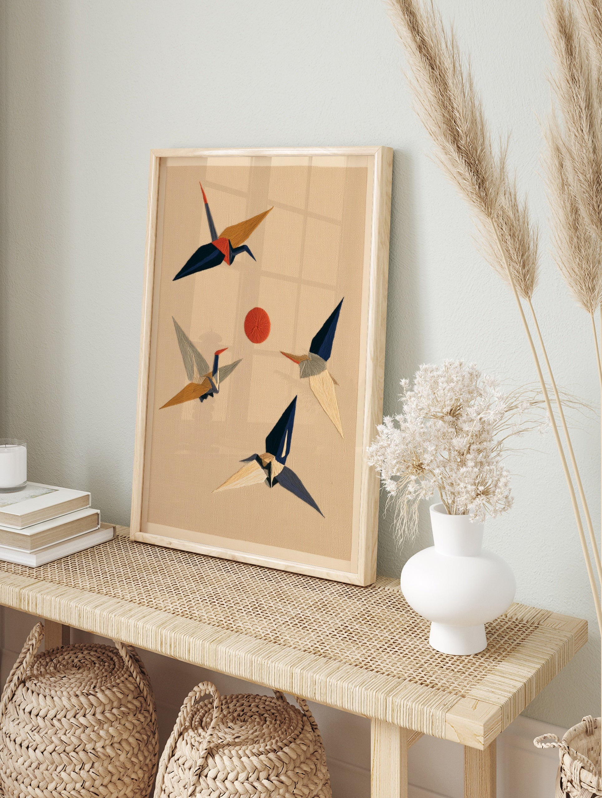 Stylised Japanese crane birds in flight around a red sun on a textured beige background, in an alternate framed mockup