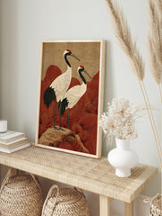 Japanese crane wall art with two red-crowned cranes on a rock, with red wave patterns and a, in an alternate framed mockup