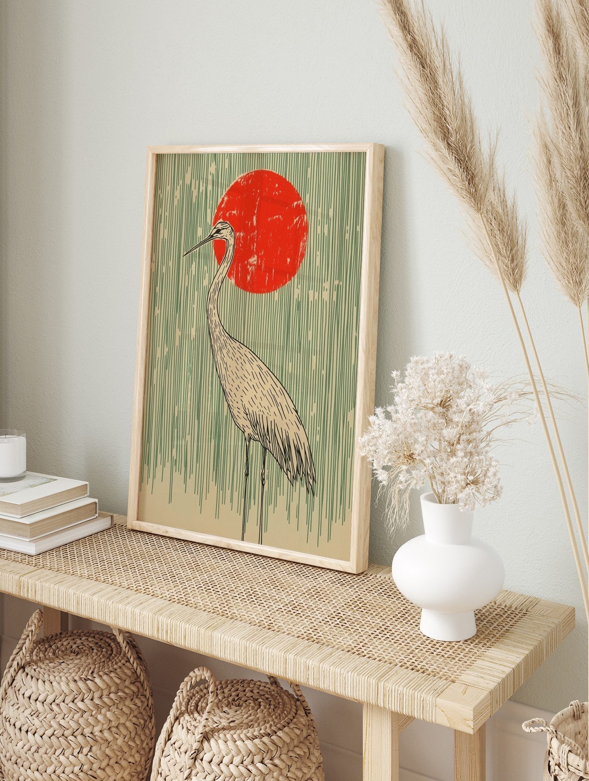 Illustrative Japanese crane standing against a red sun and vertical green lines on a beige, in an alternate framed mockup