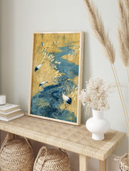 Japanese art print of red-crowned cranes in a golden reed field with a swirling blue river, in an alternate framed mockup