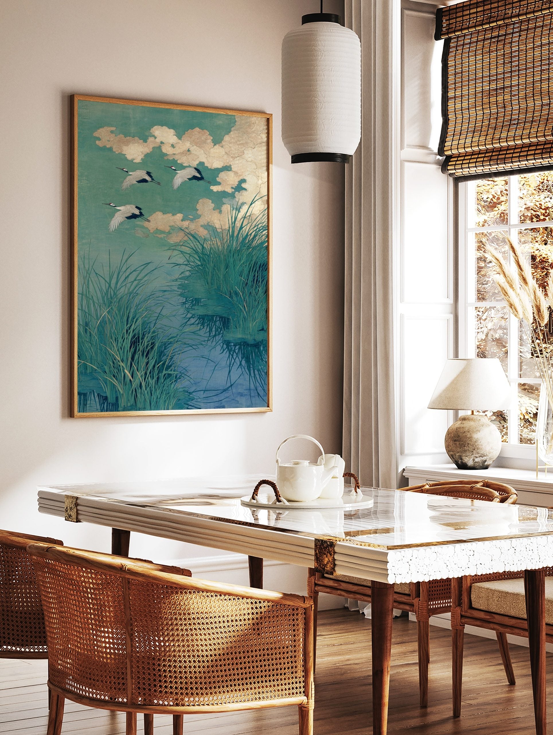 Japanese cranes in flight over water with green reeds and golden clouds, illustrative art print, in a styled room mockup