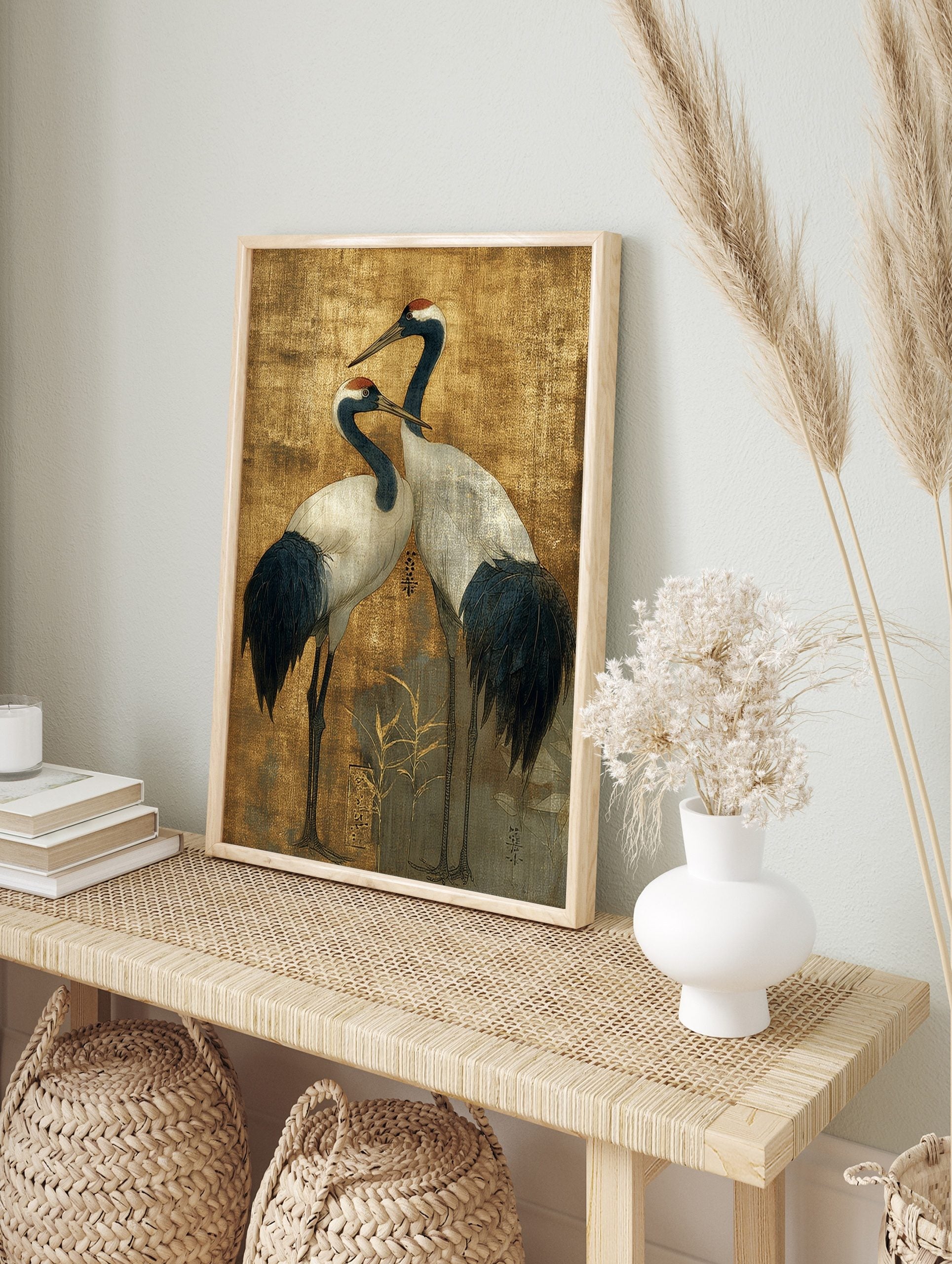 Two elegant Japanese Red-crowned Cranes with dark blue and white plumage on a textured golden, in an alternate framed mockup