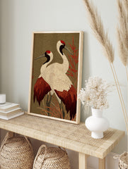 Two red-crowned Japanese cranes with white, red, and black plumage standing in red foliage, in an alternate framed mockup