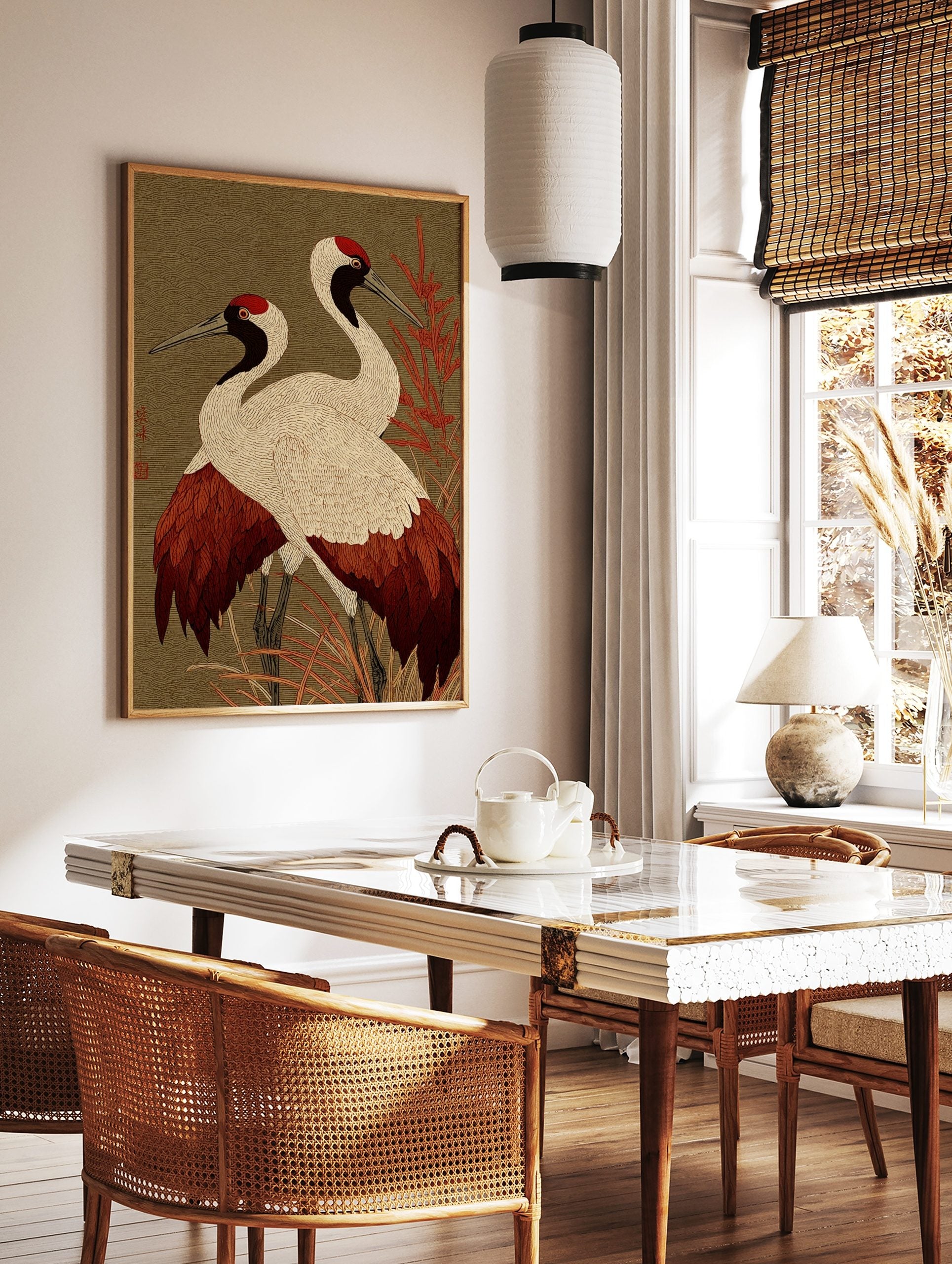 Two red-crowned Japanese cranes with white, red, and black plumage standing in red foliage against, in a styled room mockup