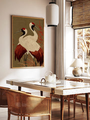 Two red-crowned Japanese cranes with white, red, and black plumage standing in red foliage against, in a styled room mockup