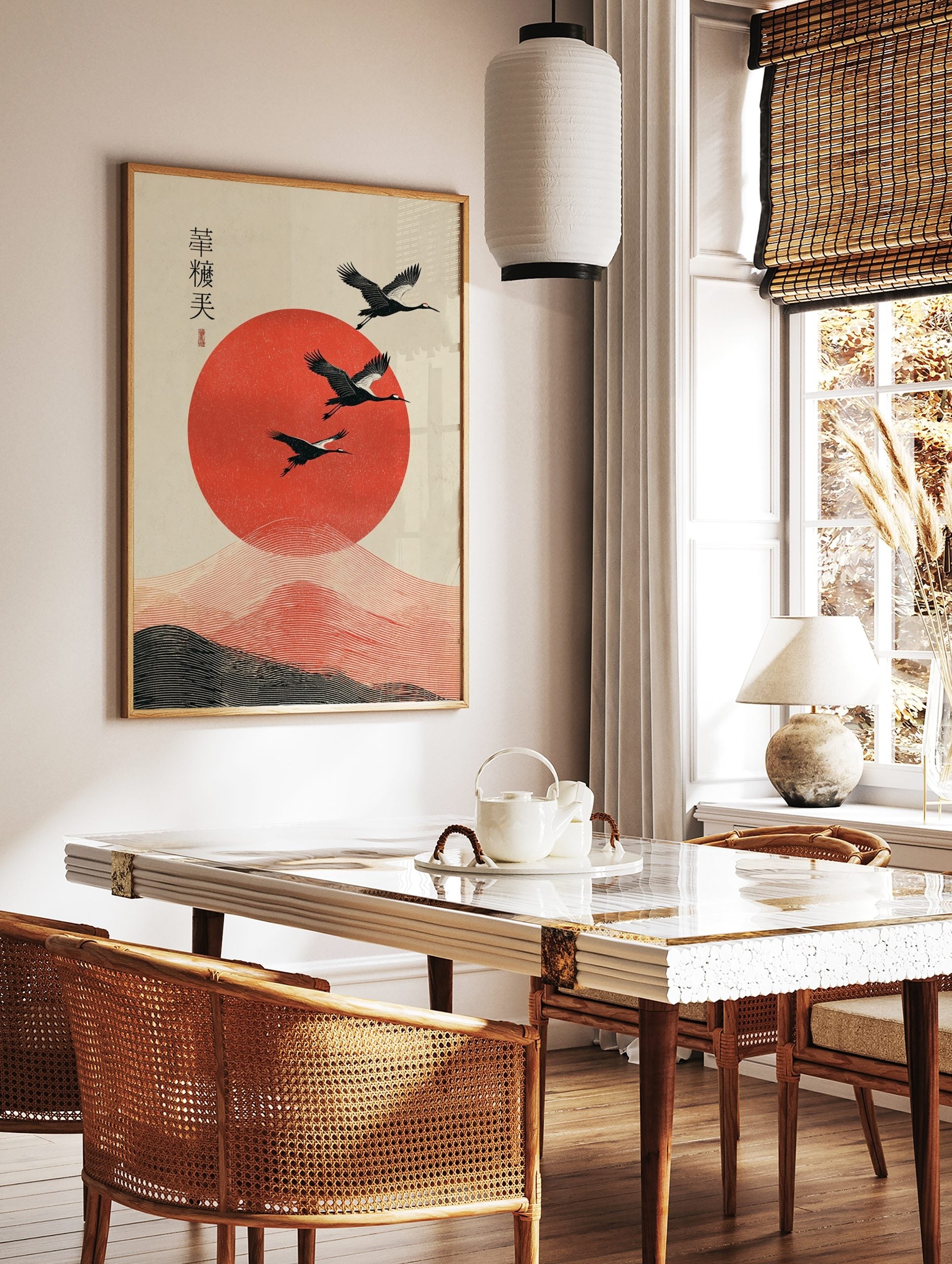 Three black cranes fly over a large textured red sun with wavy lines and Japanese calligraphy on a, in a styled room mockup