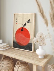 Japanese crane wall art with three black birds flying over a red sun and stylised waves, in an alternate framed mockup