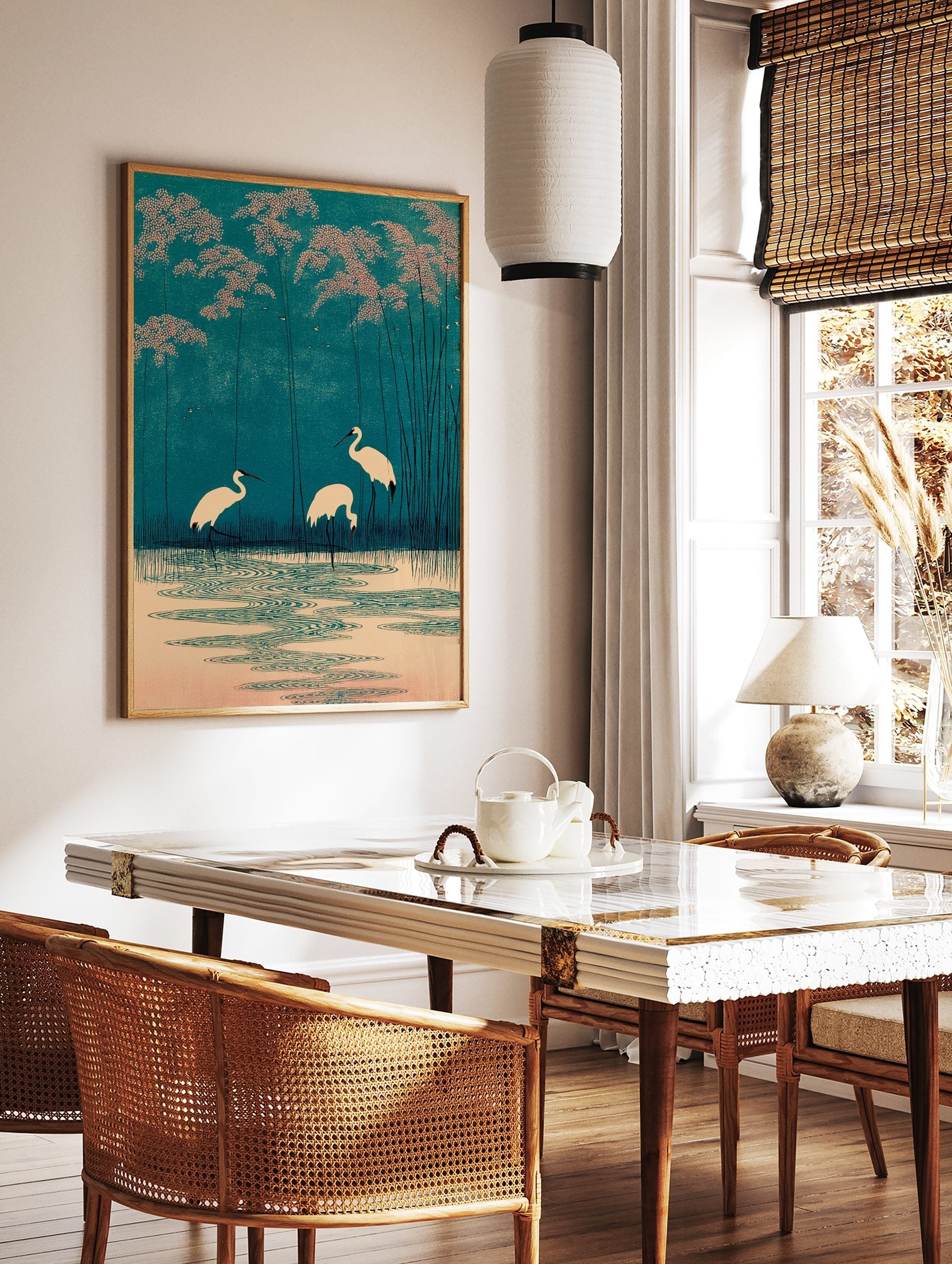 Japanese woodblock style print of three white cranes in teal water with pink foliage and tall reeds, in a styled room mockup