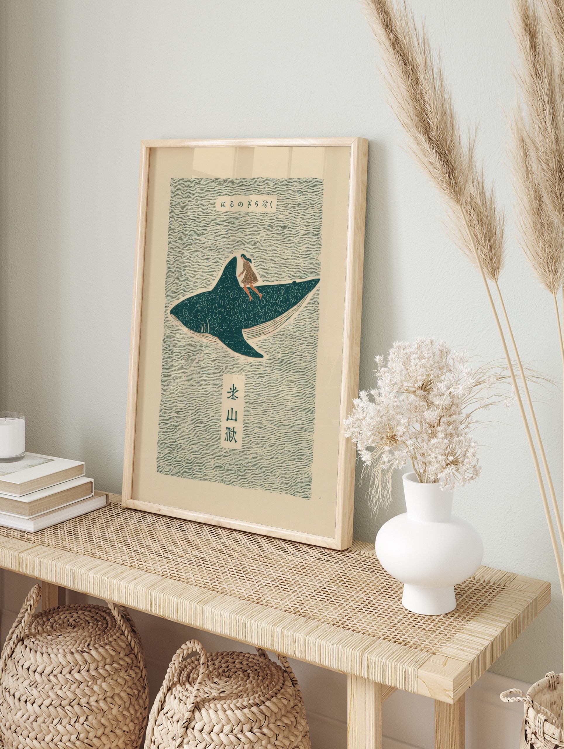 Japanese folk art print of a woman riding a spotted whale shark on wavy teal water with Kanji, in an alternate framed mockup