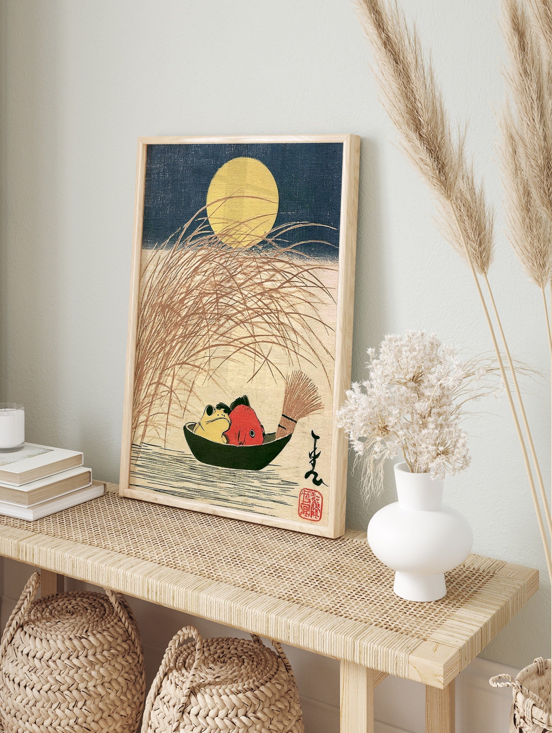 Japanese woodblock-style print of a yellow frog and red fish in a boat under a full moon with, in an alternate framed mockup