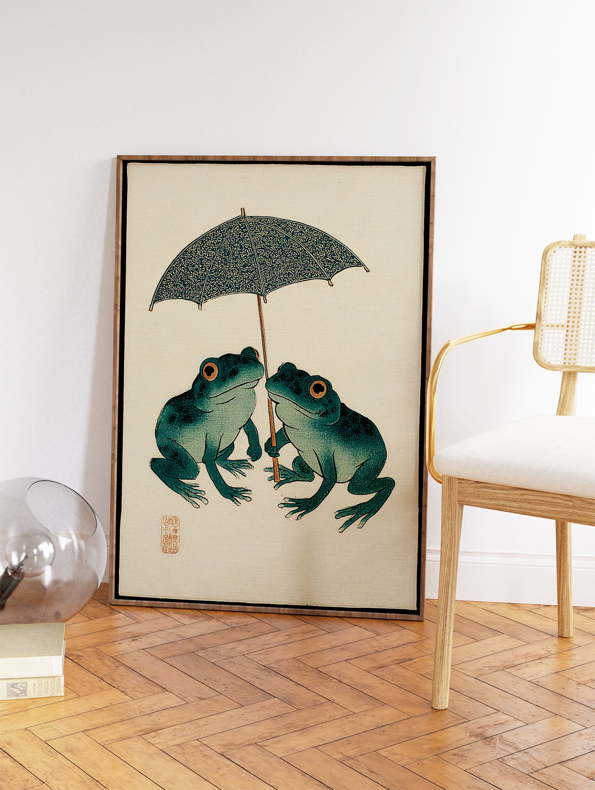 Japanese Frog Art print of two teal frogs with orange eyes sharing a patterned blue umbrella on a beige background. - Image 2