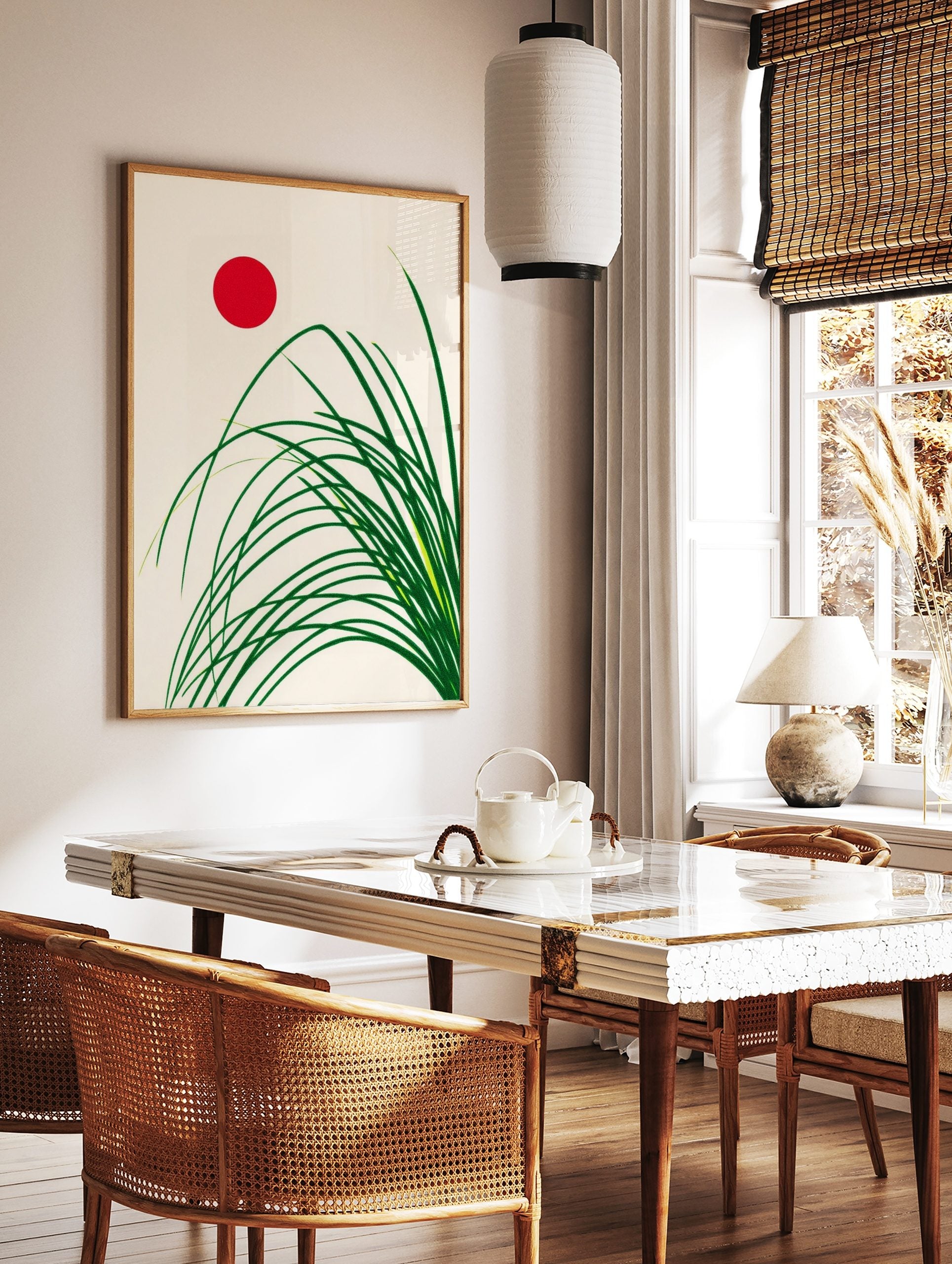 Minimalist Japanese style art print with green grass stalks and a red sun on a cream background, in a styled room mockup