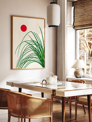 Minimalist Japanese style art print with green grass stalks and a red sun on a cream background, in a styled room mockup