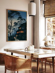Japanese house art print at twilight with glowing windows, silhouetted pine trees, and a winding, in a styled room mockup