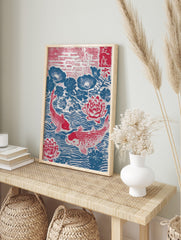 Japanese woodblock print of two red koi fish swimming among red lotus flowers and blue lily, in an alternate framed mockup