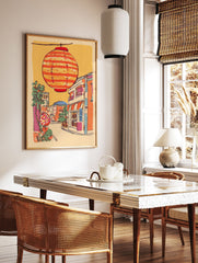 Illustrative print of a Japanese street scene with a large orange striped lantern hanging above colorful buildings and trees. - Image 2