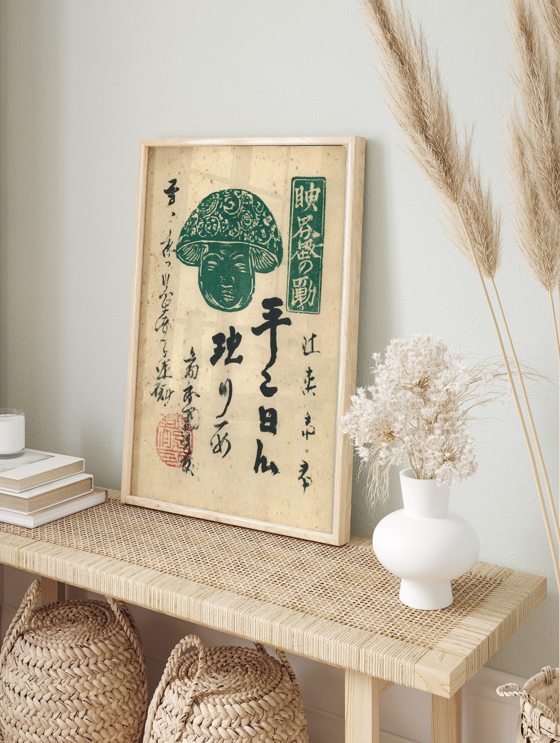 Green Japanese mushroom deity figure with human face, ornate cap, black calligraphy, and red, in an alternate framed mockup