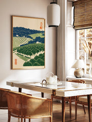 Japanese landscape woodblock style print of a terraced orchard with orange trees, blue hills, and, in a styled room mockup