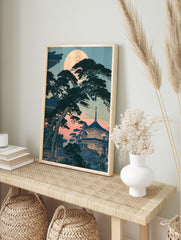Japanese pagoda with pine trees under a full moon, illustrative twilight landscape art print, in an alternate framed mockup