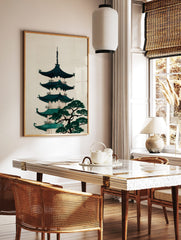 Illustrative Japanese pagoda with teal roofs and a green pine tree on a cream background, in a styled room mockup