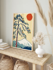 Japanese woodblock style print of a pine tree with red sun and snow-capped mountain landscape, in an alternate framed mockup