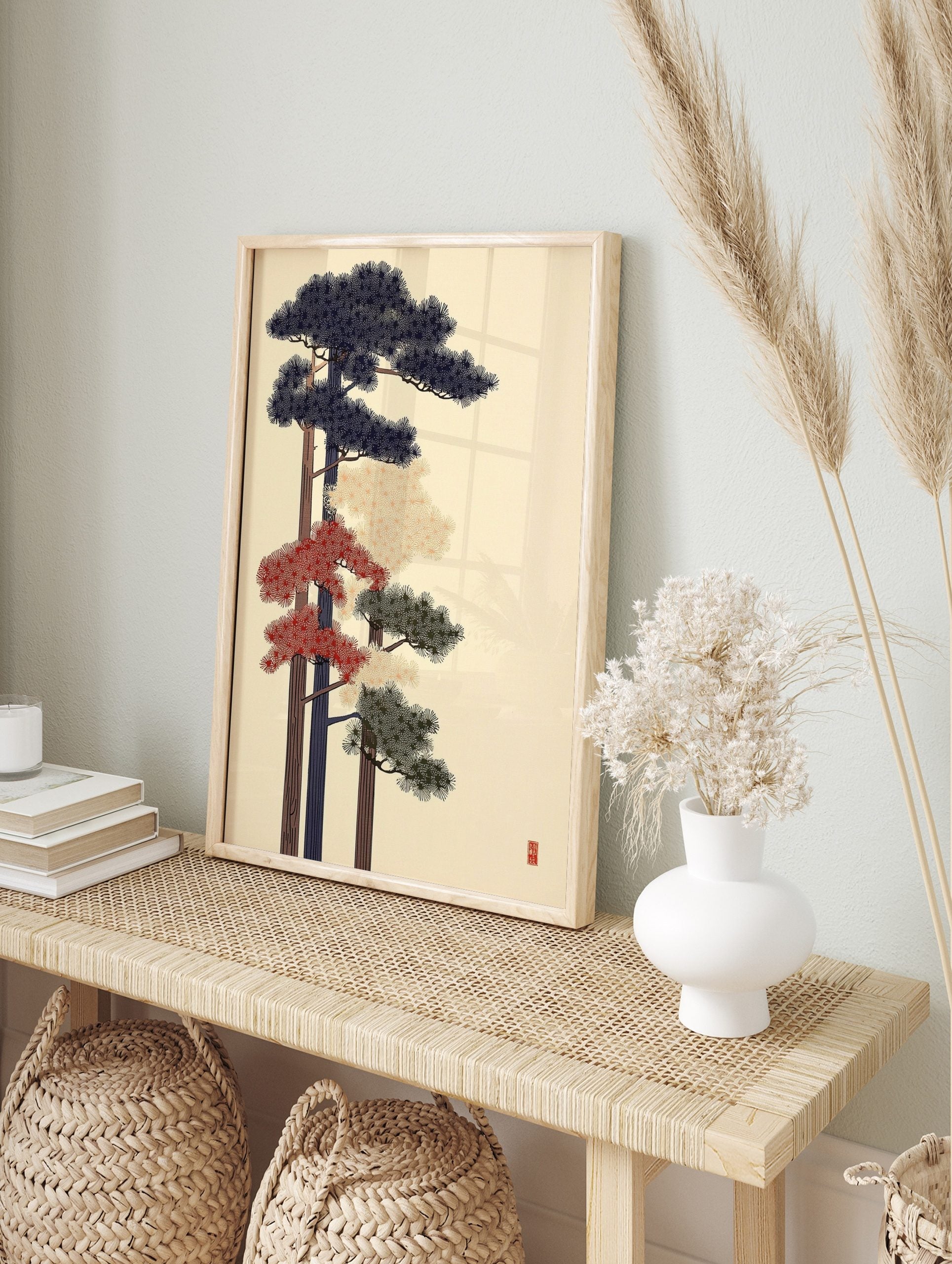 Stylised Japanese pine tree art print with navy, red, and green foliage on a light background, in an alternate framed mockup