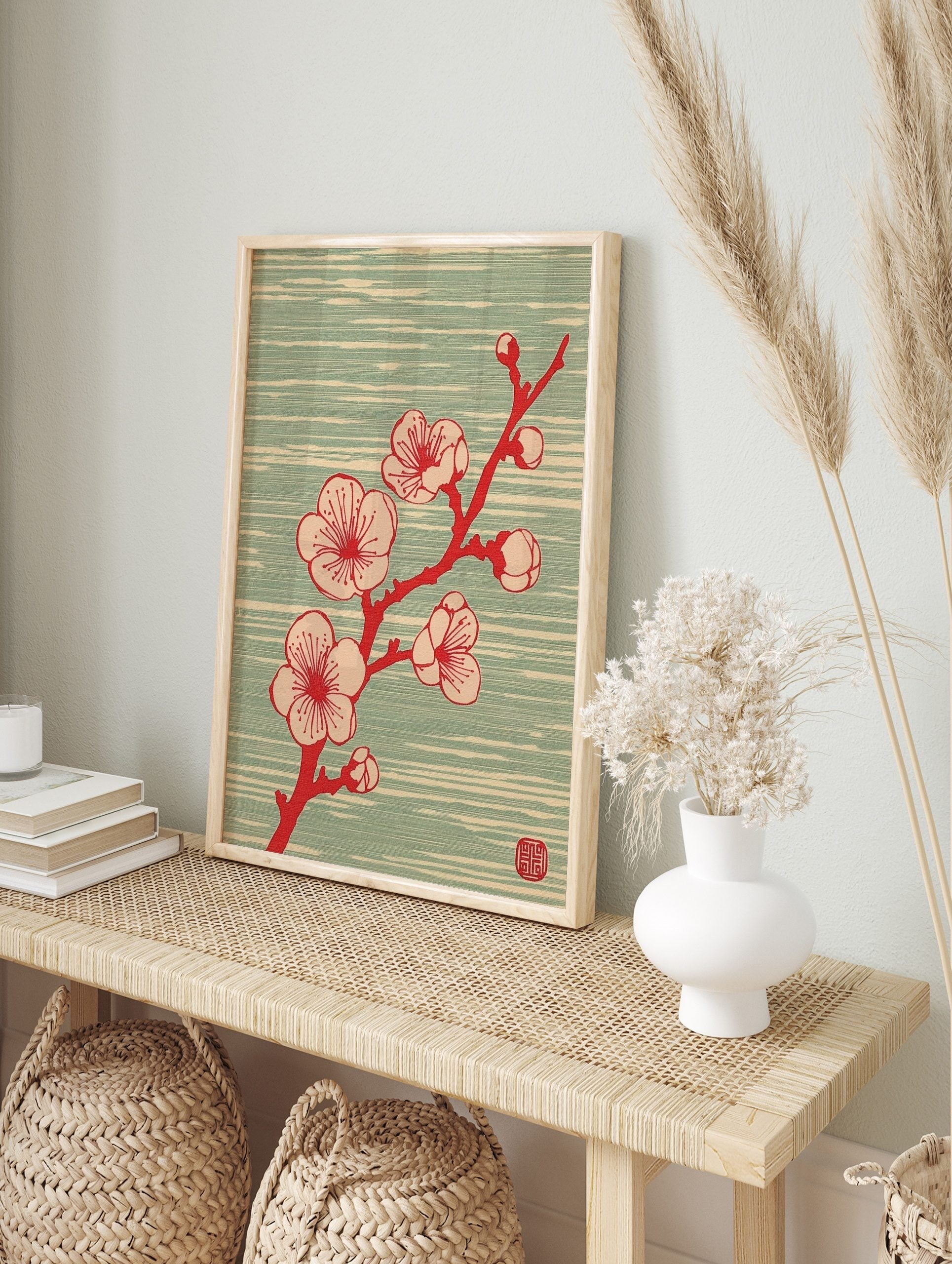 Japanese plum blossom branch with red and beige flowers on a pale teal textured background, in an alternate framed mockup