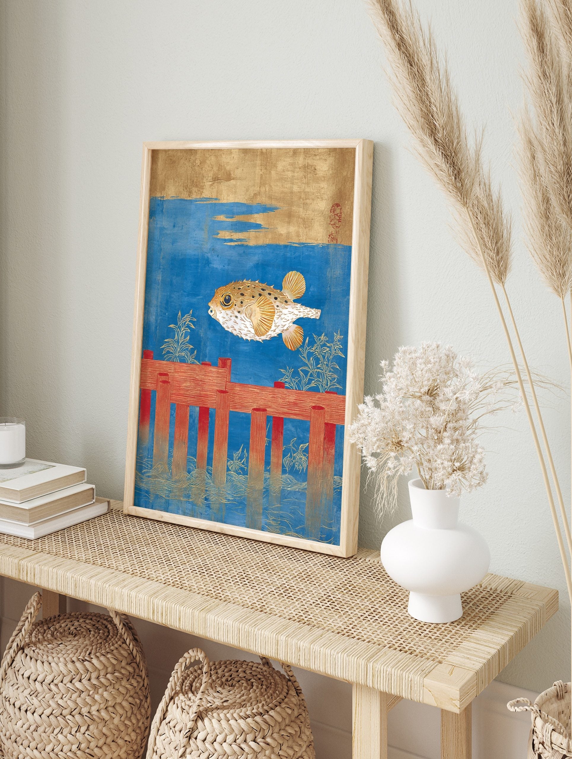 Japanese pufferfish art print with a golden fugu swimming above red wooden posts in blue, in an alternate framed mockup